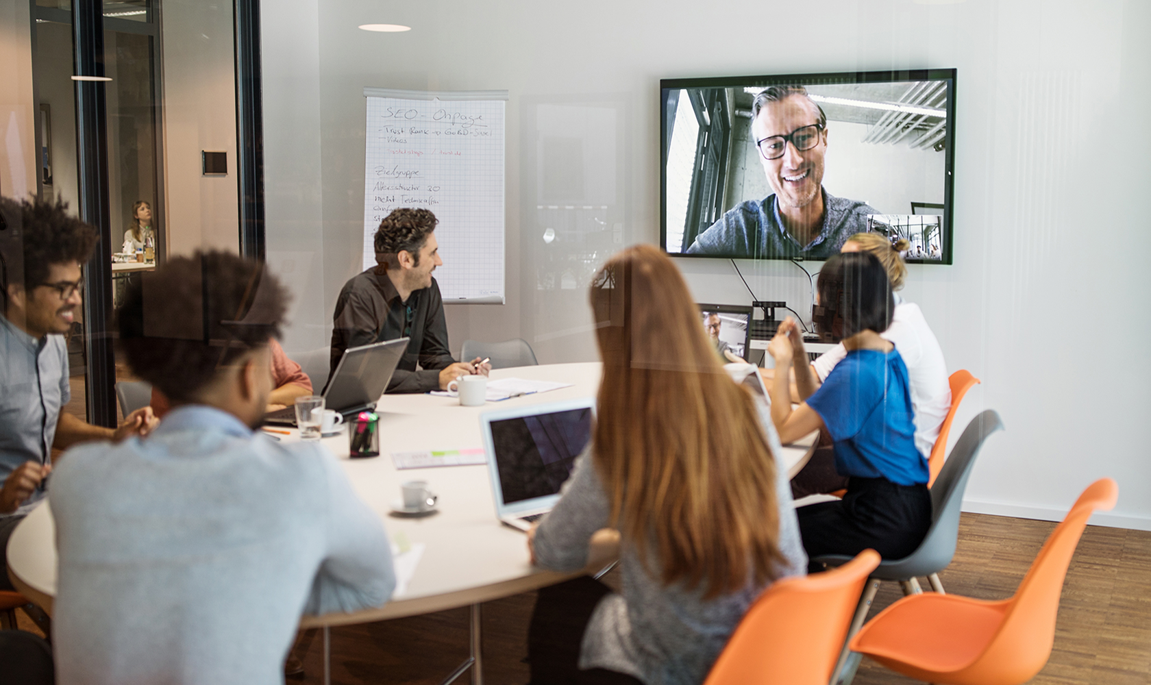People gathered around table on virtual conference call