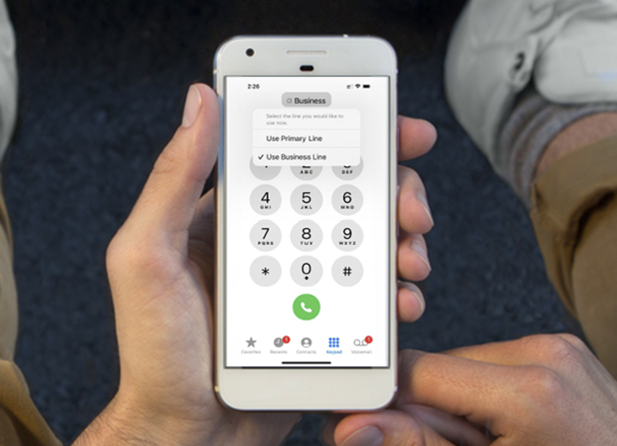 Person holding cellphone looking at the keypad.